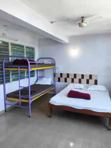 a room with two bunk beds and a bed at VISHAKA RESIDENCY yercaud in Siddhma