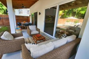 a patio with a couch and chairs and a table at Casa Rivera - 4 Bedrooms in West Bay