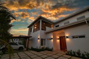 a white house with a sunset in the background at Casa Rivera - 4 Bedrooms in West Bay