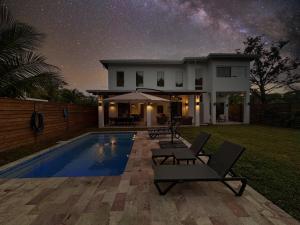 a house with a swimming pool at night at Casa Rivera - 4 Bedrooms in West Bay