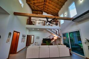 a living room with a white couch and a ceiling at Casa Rivera - 4 Bedrooms in West Bay +35 photos