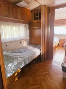 an empty bed in a small room in an rv at Hacienda Caravan in Szentes