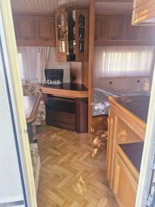 a room with a kitchen and a desk in a rv at Hacienda Caravan in Szentes +35 photos