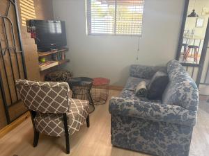 a living room with a couch and a chair at StayComfy on Jasmin in Oakdale