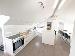 a kitchen with white appliances and a dining room at Family Apartments Monika - sea view - heated pool in Punat