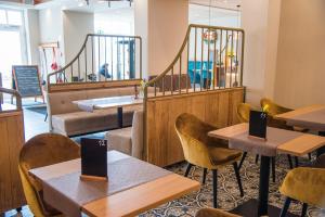 a restaurant with tables and chairs and a staircase at Markthotel Warendorf in Warendorf