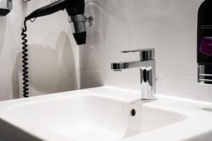 a bathroom sink with a faucet and a phone at MICE Collection Hotel Trier Business- und Stadthotel an der Mosel nahe SWT Arena und Viking Anleger in Trier +20 photos
