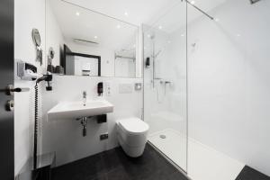 a bathroom with a toilet and a sink and a shower at MICE Collection Hotel Trier Business- und Stadthotel an der Mosel nahe SWT Arena und Viking Anleger in Trier