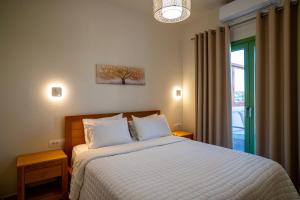 a bedroom with a bed with white sheets and a window at Liostasi Country Houses in Palekastron +88 photos