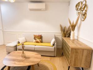 a living room with a couch and a table at Le Bohème - hyper centre - cosy in Mont-de-Marsan +18 photos