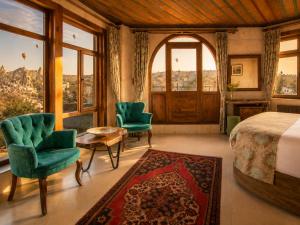 a bedroom with a bed and two chairs and a window at Premium Cappadocia in Göreme
