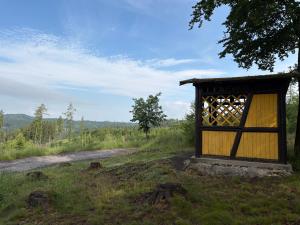 a small building in a field with a dirt road at Nature Apartment Karlovy Vary Kolová in Karlovy Vary