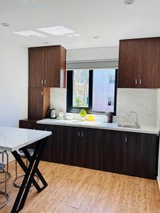 a kitchen with wooden cabinets and a white counter top at MoChy Homestay in Thôn Trường Giang +5 photos