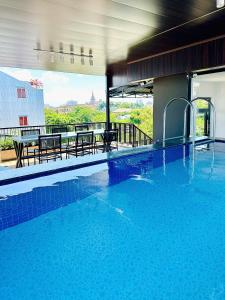 a large swimming pool with a table and chairs at MoChy Homestay in Thôn Trường Giang