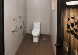 a bathroom with a white toilet in a stall at Sheen Villa Homestay in Varkala