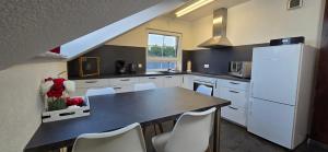 a kitchen with a table and a white refrigerator at Haus Lindengarten in Ofterdingen