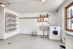 a white laundry room with a washer and dryer at Ferienhaus Victoria in Schruns