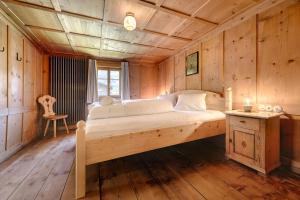a large bed in a room with wooden walls at Ferienhaus Victoria in Schruns