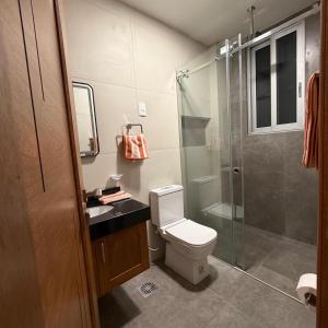 a bathroom with a toilet and a glass shower at Plaza Central Boutique House in Cochabamba