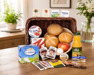 a basket full of food on a wooden table at Gauaz Boardinghouse in Maisach +5 photos