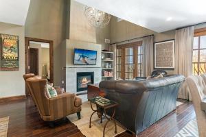a living room with a leather couch and a fireplace at 406 The Ascent in Avon