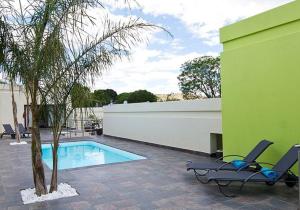 a patio with two chairs and a swimming pool at Galton House in Windhoek