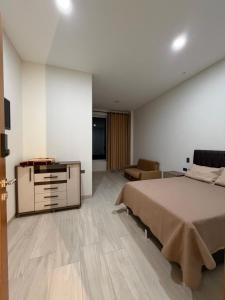 a bedroom with a bed and a dresser in it at Plaza Central Boutique House in Cochabamba