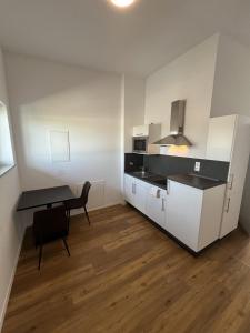 a kitchen with a desk and a table in a room at Gauaz Boardinghouse in Maisach
