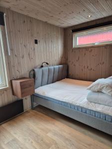 a small bed in a room with wooden walls at Måvikens havsstugor in Måviken