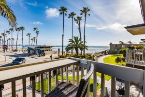 a balcony with a view of the beach and palm trees at D4 - Lighthouse on the Shore in Oceanside