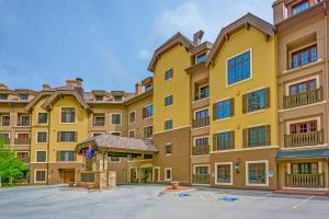 a large yellow apartment building with a courtyard at 406 The Ascent in Avon