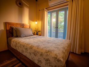 a bedroom with a bed and a large window at Garden Studio in Pātan