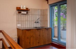 a kitchen with a sink next to a window at Garden Studio in Pātan