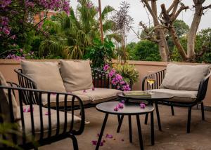 a patio with two chairs and a couch and a table at Garden Studio in Pātan