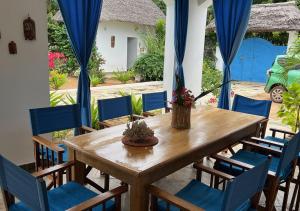 a dining room with a wooden table and chairs at Villa Rita in Gede