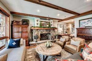 a living room with a fireplace and a table at 205 Bear Paw Lodge in Avon