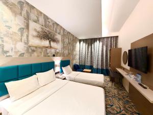 a hotel room with two beds and a tv at TAMARIND HOTEL in Dubai