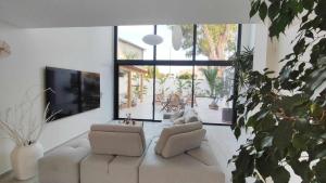 a living room with two couches and a flat screen tv at LA MAISON DE MARIE A 8 mn des plages in Perpignan