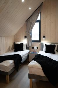 a bedroom with two beds and a window at Craftowe domki in Rusinowo