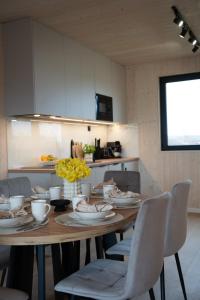 a dining room table with plates and cups and chairs at Craftowe domki in Rusinowo