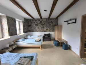 a bedroom with two beds and a couch in it at Ubytovanie u richtára in Čekovce