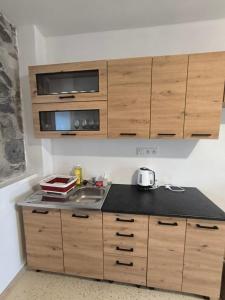 a kitchen with wooden cabinets and a counter top at Ubytovanie u richtára in Čekovce