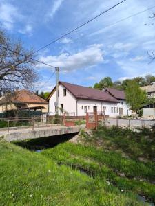 a bridge over a river in front of a building at Ubytovanie u richtára in Čekovce