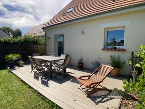 a wooden deck with a table and chairs on it at Une jolie maison climatisée pour vous reposer in Blois