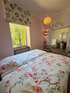 a bedroom with a bed with a floral bedspread at Le Pavillon imperial - Suite avec salle d'eau in Hannut