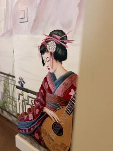 a painting of a geisha playing a guitar at Le Pavillon imperial - Suite avec salle d'eau in Hannut