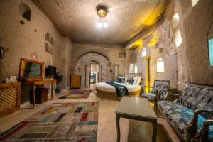 a bedroom with a bed and a couch in a room at Roma Cave Suite in Göreme