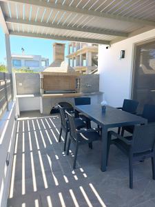 a table and chairs on a patio with a grill at Salt & Light House in Tigaki
