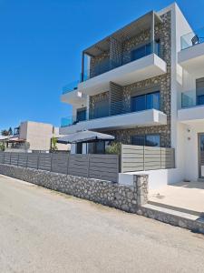 an apartment building with a stone retaining wall at Salt & Light House in Tigaki
