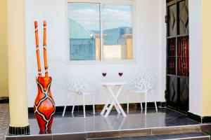 a room with two chairs and a table with a vase at Sastar Homes in Iringa